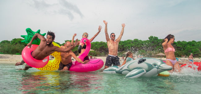 A group of people having fun with inflatable floats at the beach