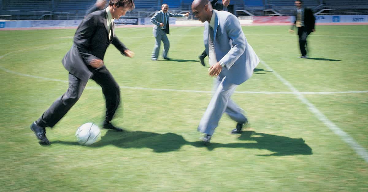Business-Men-In-Suits-Playing-Football